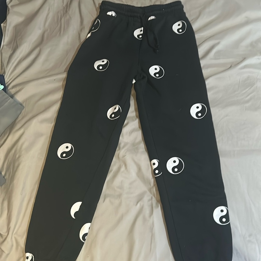 Black sweatpants with Ying-yang prints.